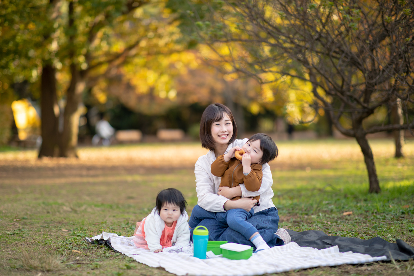 Young family enjoying picnic at public park