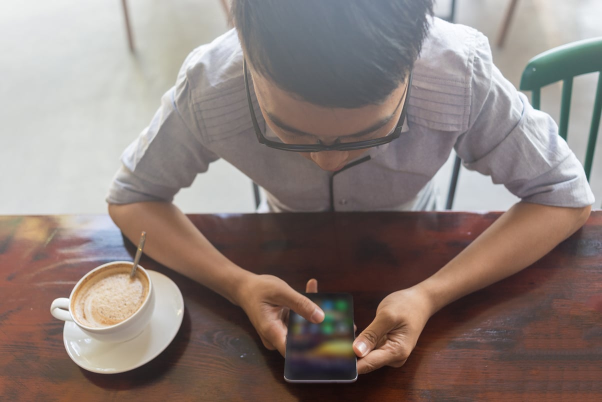 Asian student using smartphone in the coffee time